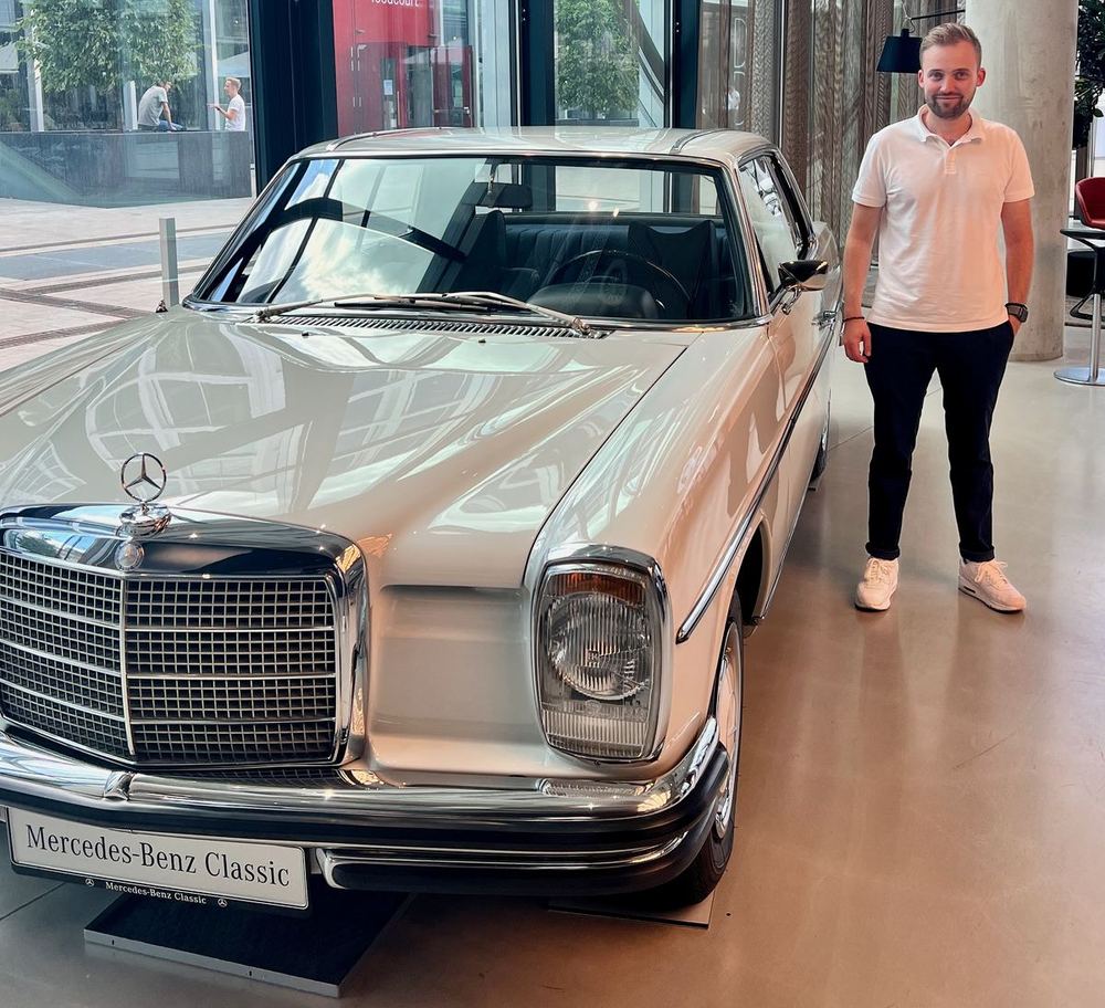 Philipp Raasch next to a classic Mercedes-Benz coupé